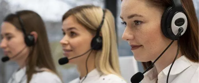 Three Telecalling girls working in a company wearing handset